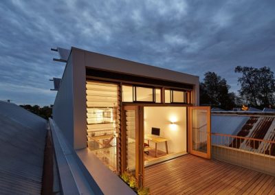 Night shot of upper deck area with wide Breezway louvres open to allow fresh air into home