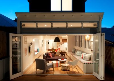 Night view of rear of fairlight house into living room with Breezway louvres