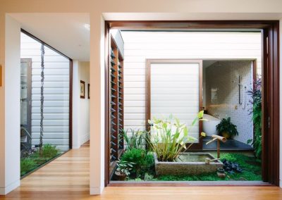 View of glass link with Breezway louvres and Japanese garden that joins old and new structures