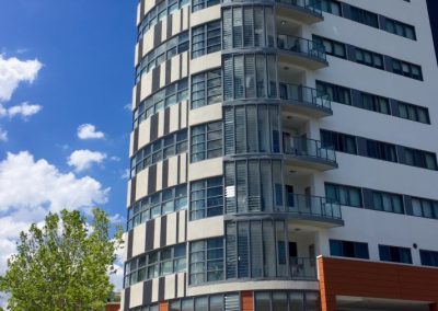 Louvre windows with the Stronghold System from Breezway were used to enclose the balcony on this multi storey apartment building